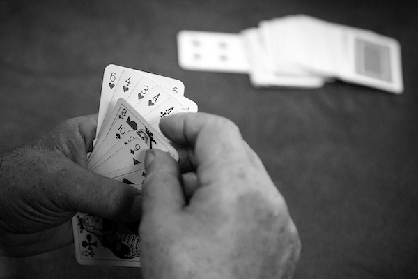 The rumored history of Hotel Villa Convento as a place for drinking and gambling, represented by a hand of cards during a card game